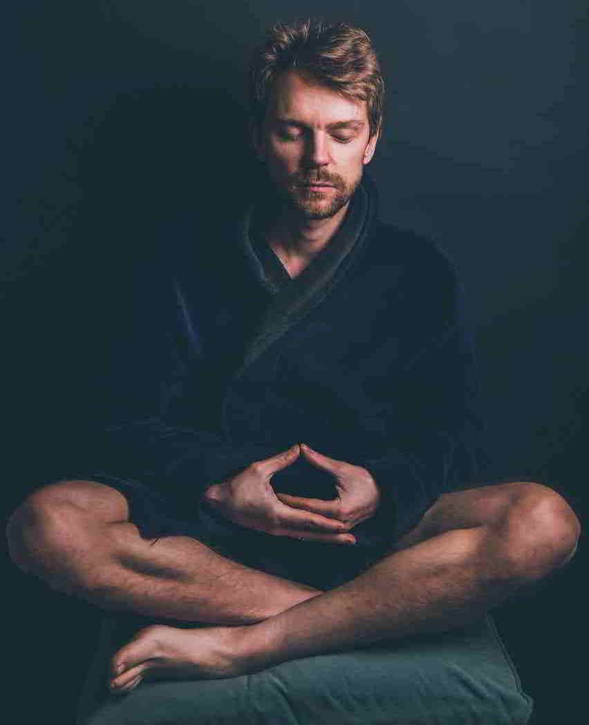 Male meditating while sitting on the floor